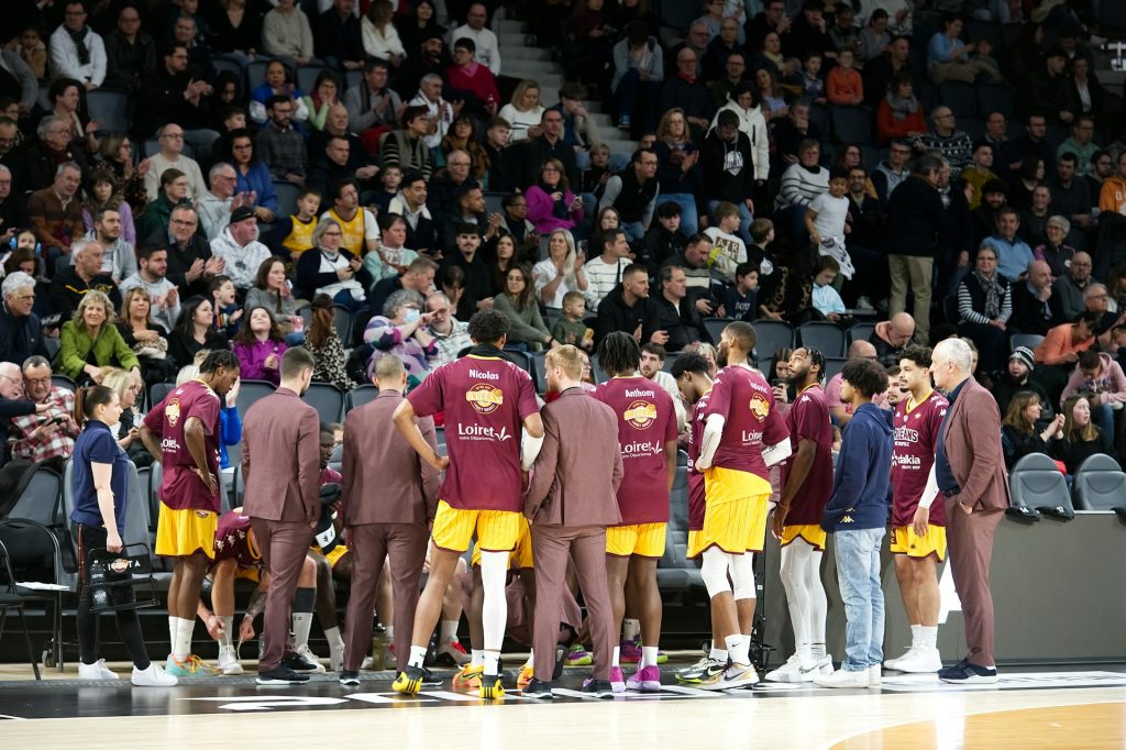 Jugadores de baloncesto escuchando indicaciones de su entrenador